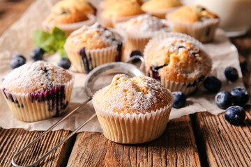 Tasty blueberry muffins on wooden background, closeup
