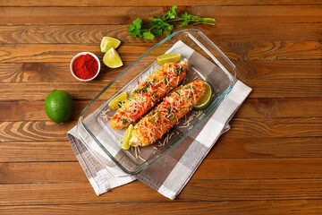Baking dish with tasty Elote Mexican Street Corn on wooden background