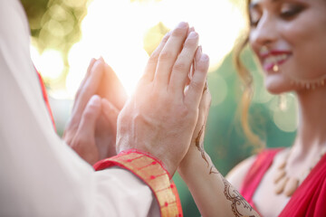 Hands of beautiful Indian wedding couple outdoors