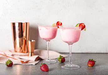 Glasses of strawberry Pina Colada cocktail and shaker on table