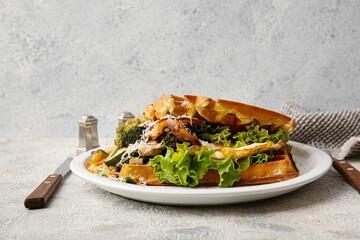 Tasty Belgian waffles with vegetables in plate on table