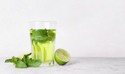 Glass of tasty mint tea with lime on white background