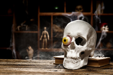 Human skull with book on table in alchemist's laboratory