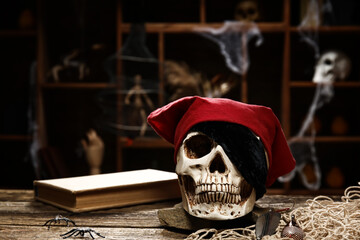 Pirate skull with book on table against dark background
