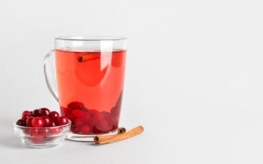 Glass cup of tasty cranberry tea with cinnamon isolated on white background