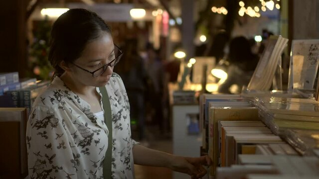 Asian woman walking at night book fair relax hobby festival