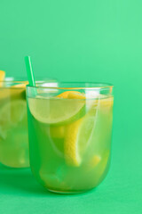 Glasses with tasty lemonade on color background