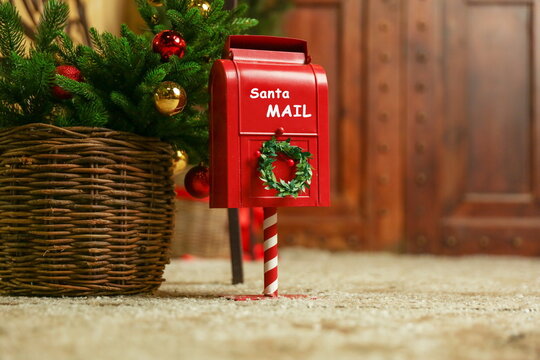red post box for letters to santa claus near the christmas tree 