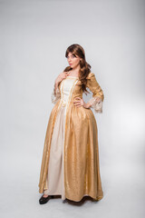 Fototapeta na wymiar A full-length portrait of a girl in a golden rococo gown posing isolated on a white background.
