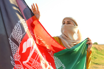 Muslim woman with flag of Afghanistan outdoors - obrazy, fototapety, plakaty