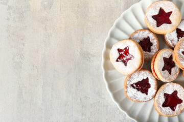 Plate with tasty Linzer cookies on grunge background
