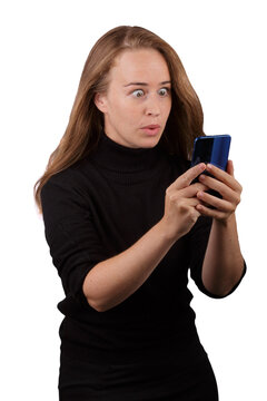 Mujer de cabello rubio con un tel&eacute;fono inteligente en las manos con cara de sorprendida