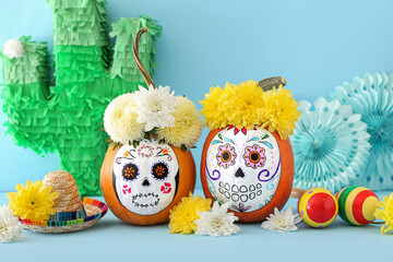 Pumpkins with painted skull on color background. Celebration of Mexico's Day of the Dead (El Dia de Muertos)