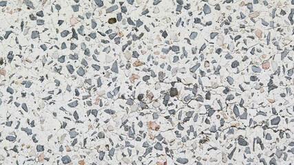 Pattern of grey gravels in the white concrete surface, Abstract view of random gravel in a white concrete wall, Close-up of grey pebbles mixed in the white concrete structure