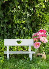 mini baby bench with pink flowers in a park