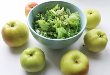 fresh salad leaves with pumpkin seeds in a plate, close-up and green apples. Comfortable digestion, proper nutrition, weight loss. The texture of vegetables, salad. Seasonal vitamins, fiber