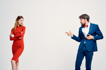 a man in a suit next to a woman in a red dress communication fashion isolated background