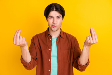 Photo of unsure angry young man wear brown shirt asking understand me isolated yellow color...