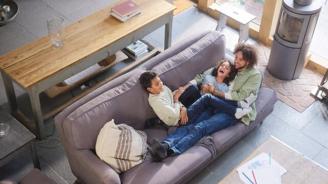 Slow motion of father and sons on sofa, high angle
