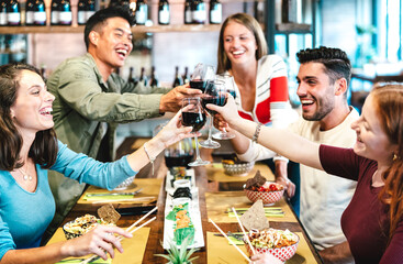 Multiracial friends toasting red wine at sushi restaurant - Food and beverage lifestyle concept...