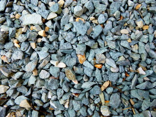 Grey ground stone rubble background of many small stones