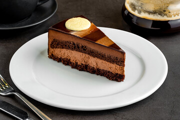 Layered chocolate cake with brewing coffee on stone table