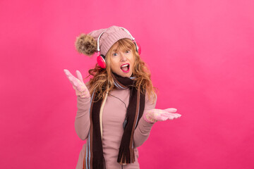 adult woman with headphones and warm or winter clothes dancing isolated