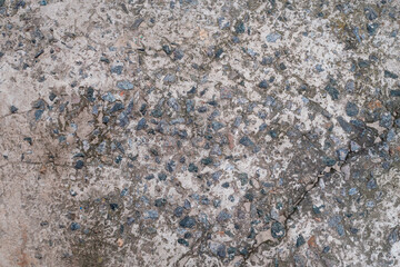 Cement floor with small stones. Dirty cracked old gray concrete background wall or floor with polished cement. Terrazzo texture. Close-up.