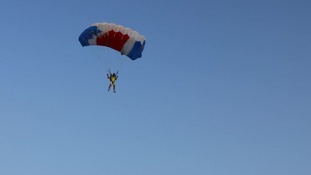 National Parachuting Championship: Parachutist is flying slowly down with an open parachute. Skydiving, gliding, parachute jump