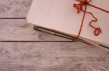 Waste paper, tied with a rope on a light wooden background. A stack of unnecessary papers and...
