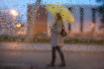Young beautiful woman in a blur holding a yellow umbrella