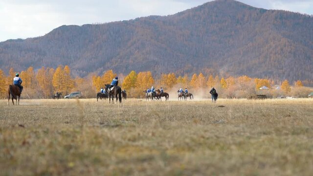National traditional horseback game of Asian people - Buzkashi, kokpar or kupkari. Male riders on horses play match game in teams. Altai highland valley, steppes on background. Ulak tartysh polo sport