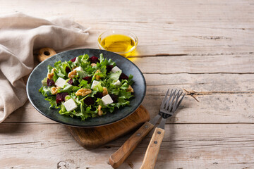 Beetroot salad with feta cheese,lettuce and walnuts on rustic wooden table. Copy space