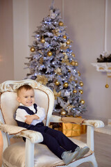 Little boy in a costume waiting for a Christmas near the christmas tree