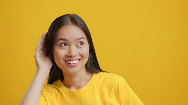 Asian Woman Listening Opposite Sides Approving And Disapproving Information, Studio
