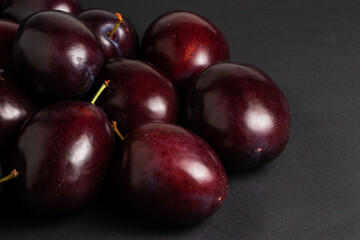 Fresh organic plums on dark background