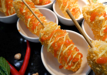 Skewered nuggets with sauce and mayonnaise topping