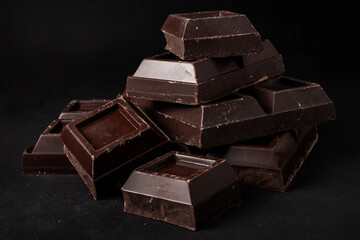 Pieces of dark chocolate on a dark background