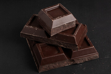 Pieces of dark chocolate on a dark background