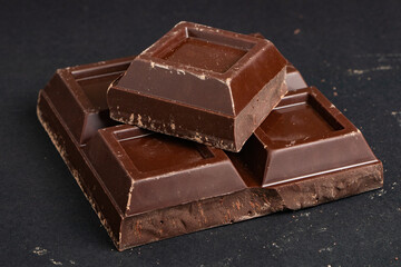 Pieces of dark chocolate on a dark background