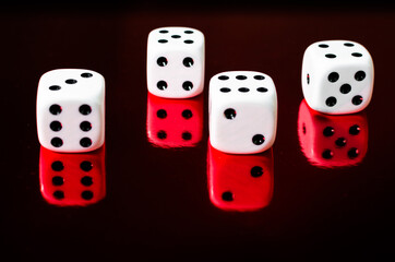 Closeup shot of four dice on a red mirroring surface