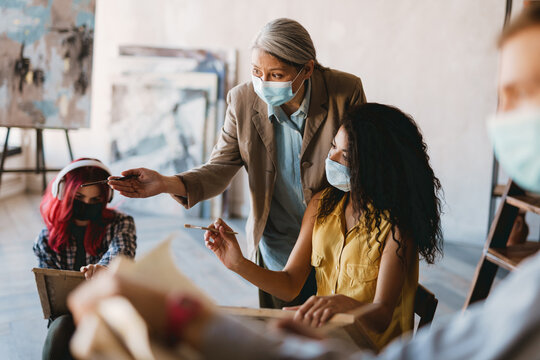 Mature teacher talking with her student during class at art school - Powered by Adobe