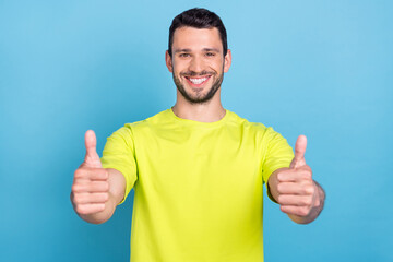 Portrait of attractive cheerful guy giving thumbup ad trust isolated over bright blue color background