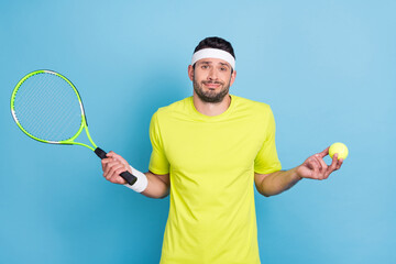 Photo of clueless young man tennis player shrug shoulders no idea hold racket isolated on blue color background