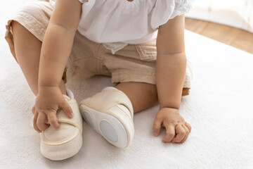 ベビーシューズを履いて、座っている赤ちゃんの足(1歳2か月、女の子、日本人)