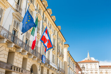 Fototapeta premium Turin, Italy. May 12, 2021. The flag of Europe, Italy and the Piedmont Region flutters on the facade of the historic building seat of the Government of the Piedmont Region in Piazza Castello.