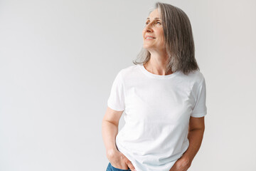 Grey senior woman in t-shirt smiling and looking aside