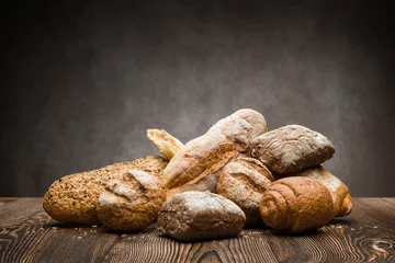 Fotobehang assortment of baked bread on wooden table © winston