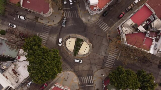 Aerial top down view of Roundabout in Parque Chas Buenos Aires, Argentina. Drone flying top of a intersection and light traffic on the road.
