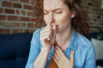 Caucasian red head woman coughing and having lungs infection - obrazy, fototapety, plakaty